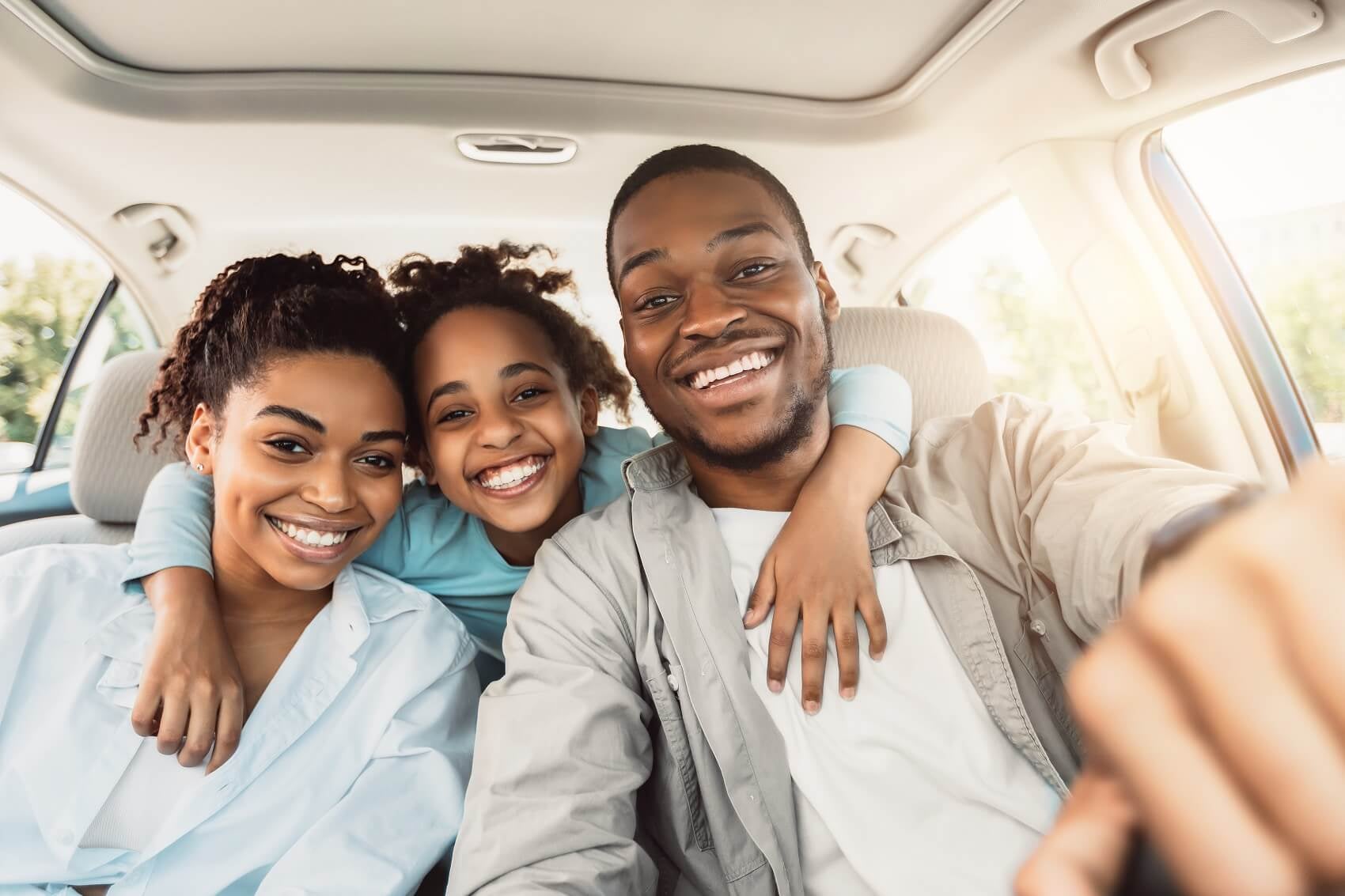 Happy family of three in their new car
